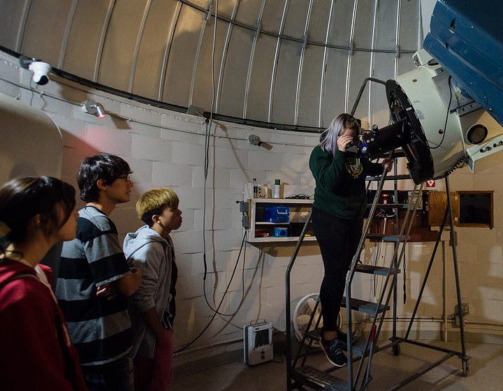 Teacher and students with telescope