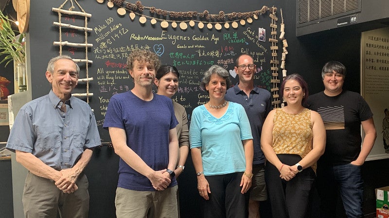 Psychology faculty members standing in front of a blackboard
