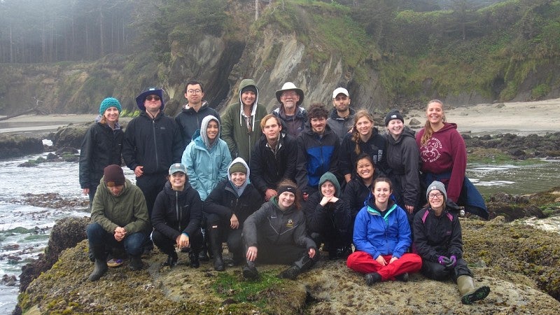 student group on top the rock in the shore