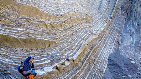 A photographer sits on a mountain 