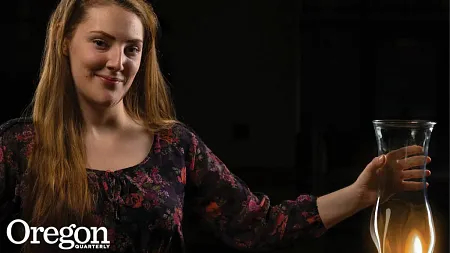 Nicole Wales posing with a glass beaker melting over a flame