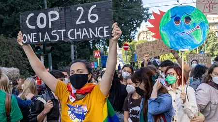 people protesting climate change with signs at COP26 meeting