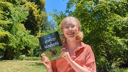 Abby Lewis with her book