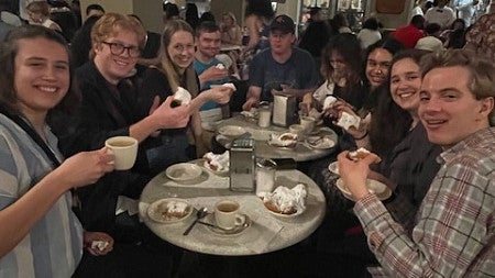 smiling people sitting at tables in a café