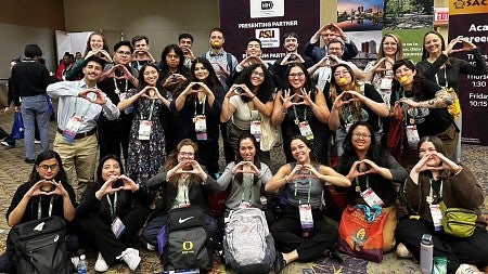 A group of students making an O shape with their hands
