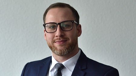 a smiling person wearing a suit nd tie