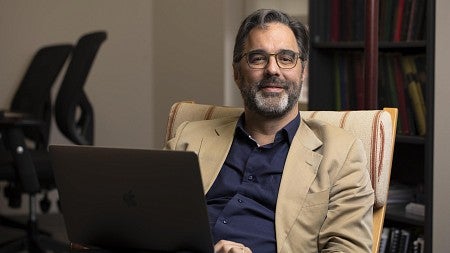 a person sitting in a chair with a laptop