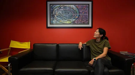 a person sits on a couch in front of a red wall