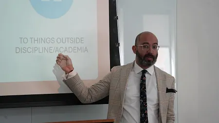 a person talks and points to a slide during a presentation