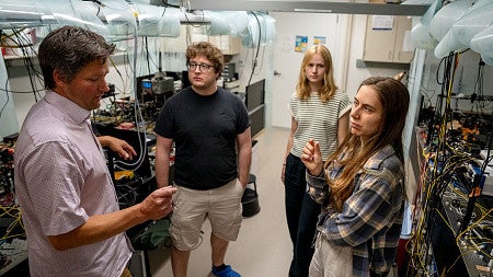 A group of people talk in a lab