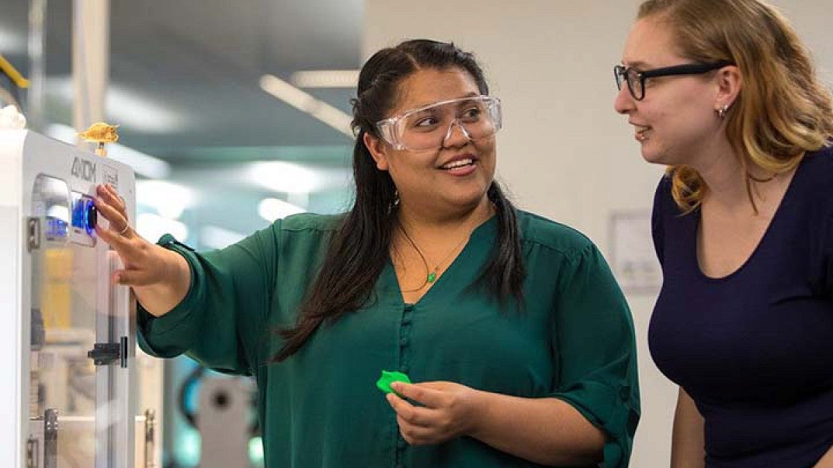 Two PHd students working with 3D printer