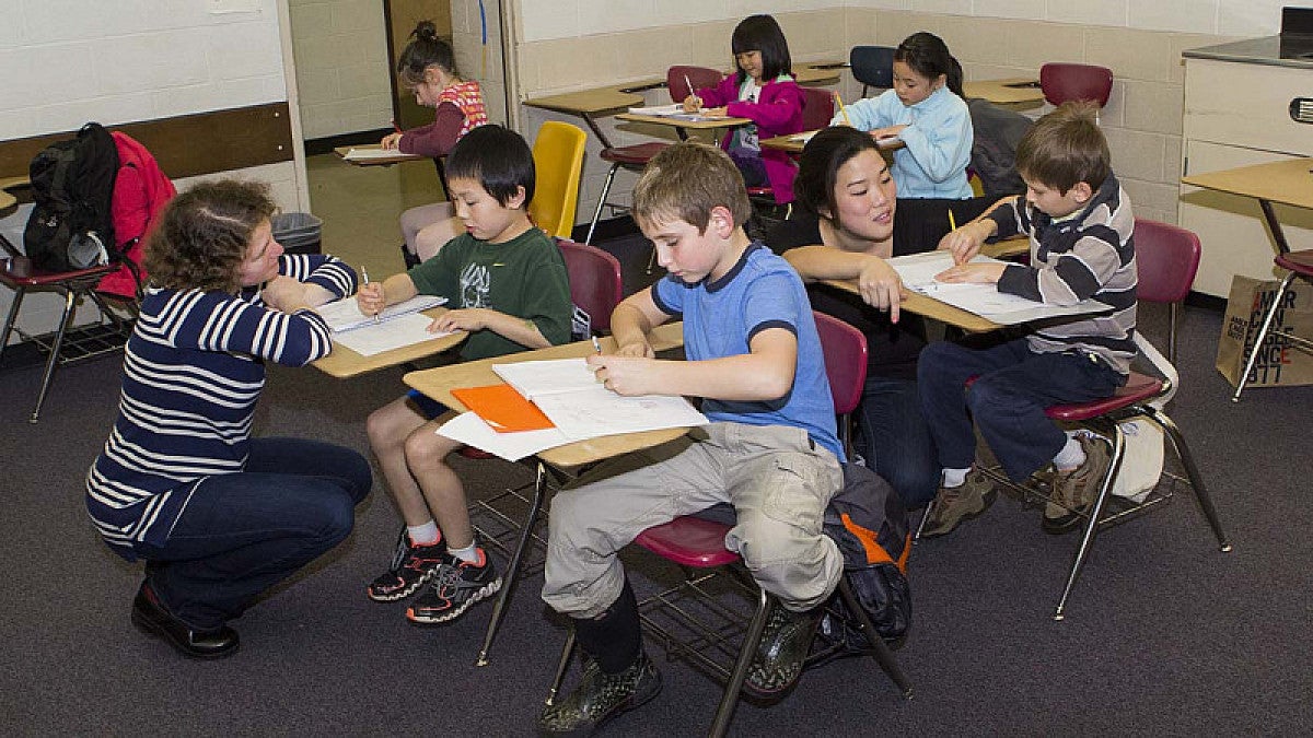 Math students working with children at desks