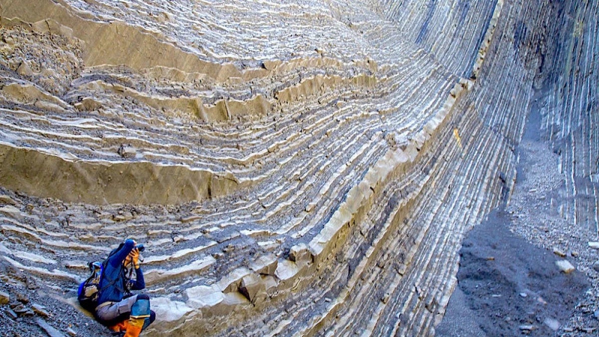Researcher sitting on rock shelf
