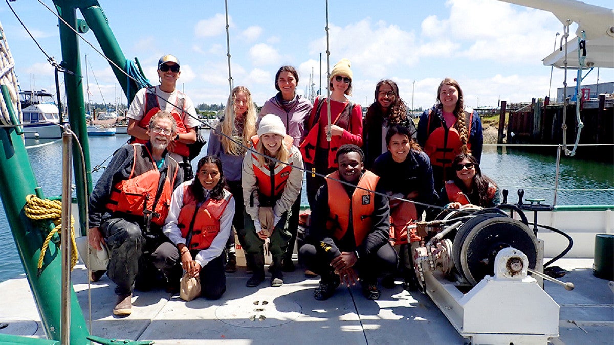 Group of marine biology students posing on a boat