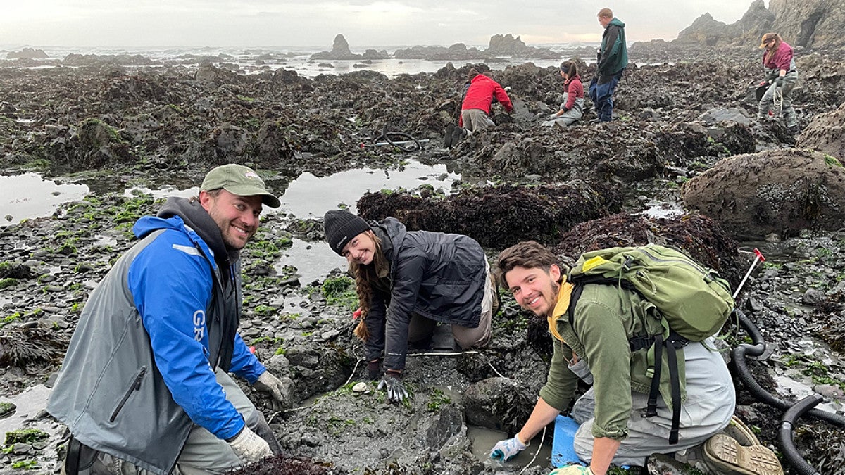 Students and teacher exploring coast for marine biology samples