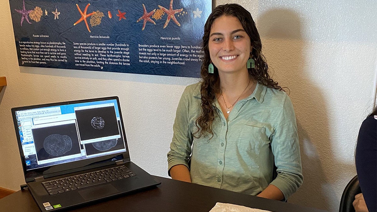 Student sitting next to display of marine biology samples