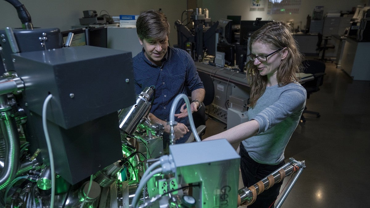 two scientists looking at lab equipment related to material science
