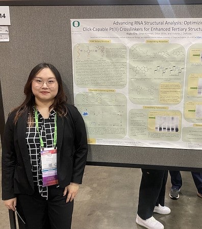 Student standing beside research poster