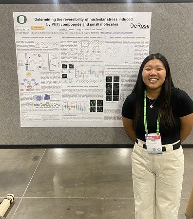 Student standing in front of a research poster