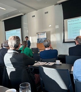 A speaker delivers a lecture to a room of professionals