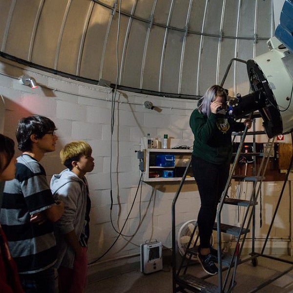 Teacher and students with telescope