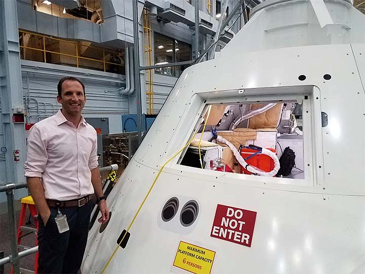 Steve Laurie at NASA, standing next to space capsule