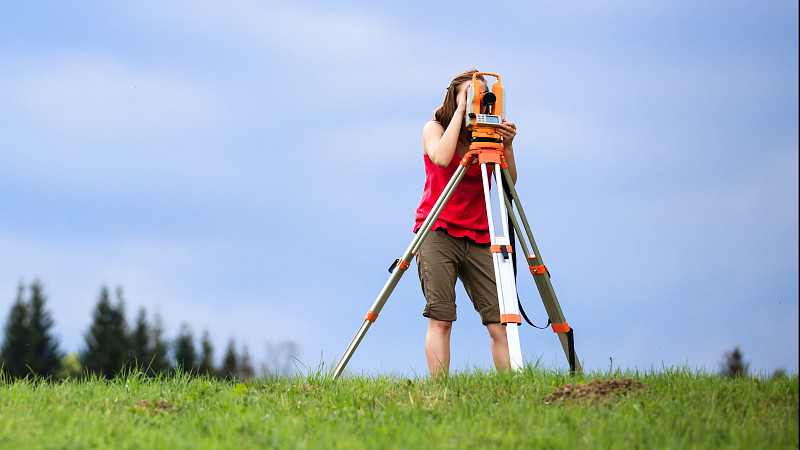 Young female land surveyor at work