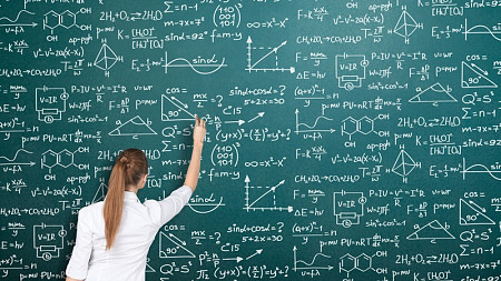 A women does math on a chalk board