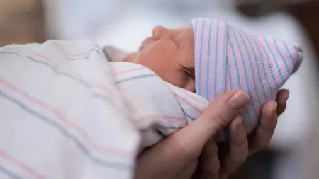 Newborn being held