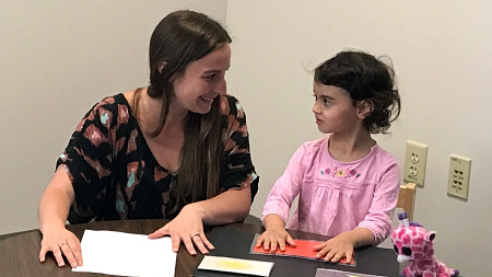 Psychology student working with a child