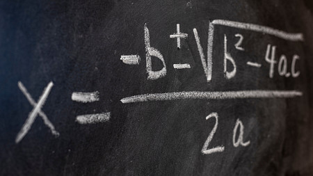 a black board with the quadratic equation written in white chalk