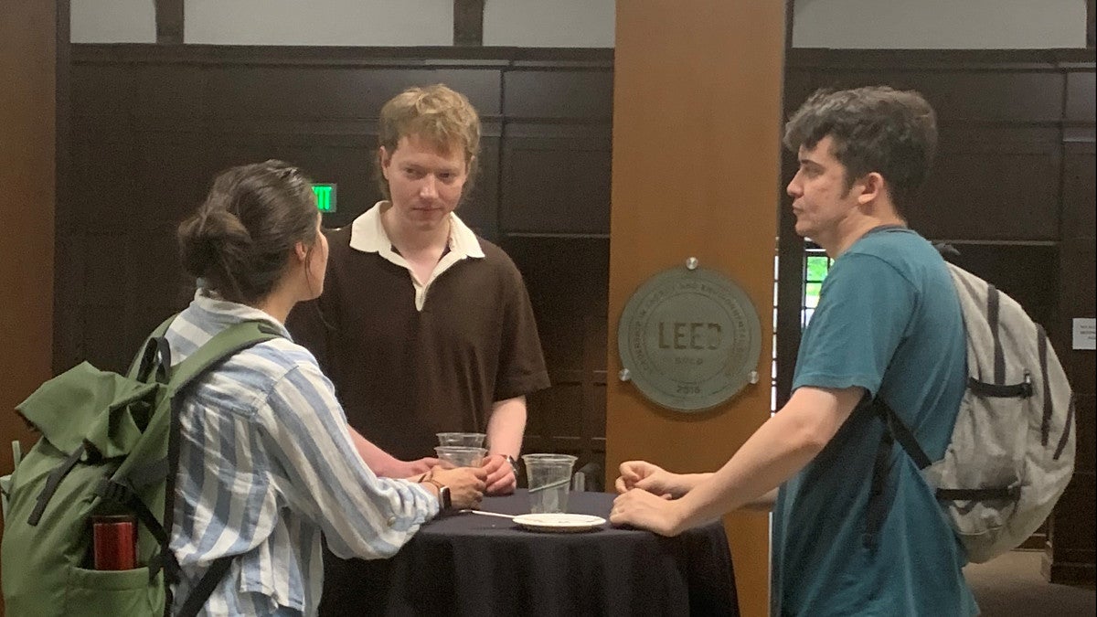 Group of students standing at a table talking