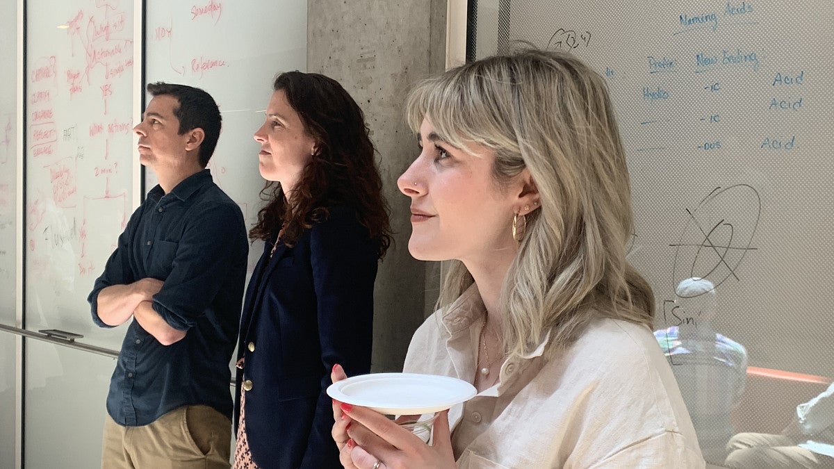 Psychology faculty and PhD student standing in front of a whiteboard
